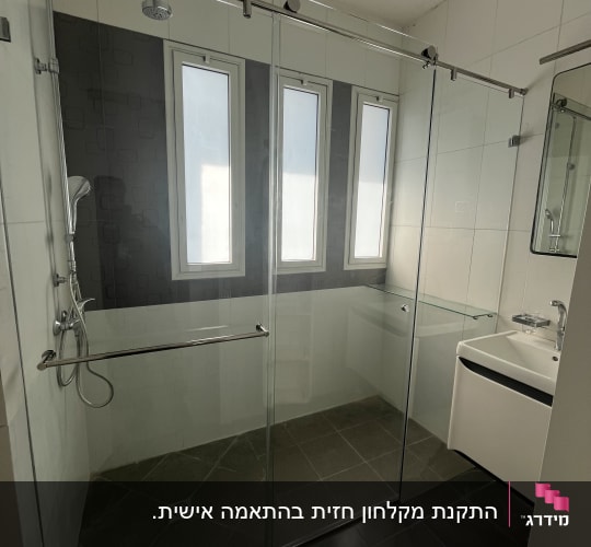 מקלחון זכוכית עם ראש מקלחת וכיור בחדר אמבטיה מודרני